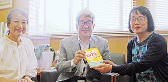 千葉教育長（中央）に書籍を手渡す江川さん（右）。左は協会の和崎千英子さん