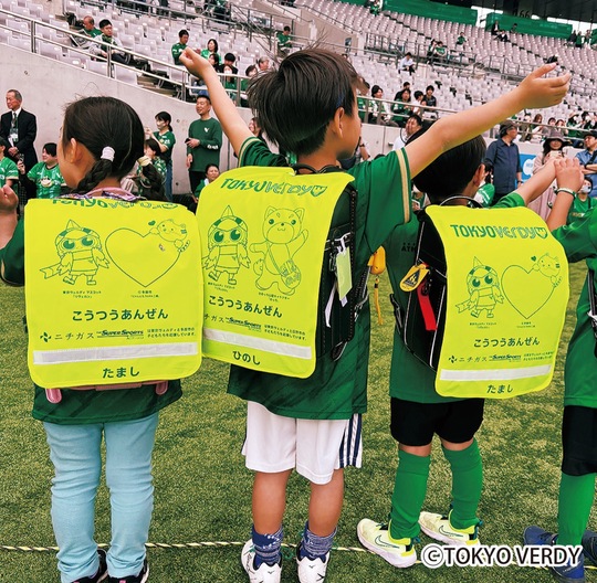 スタジアムでランドセルを背負う児童