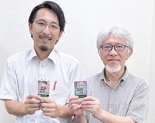 自身のトレカを手にする出岡さん（左）と石飛校長