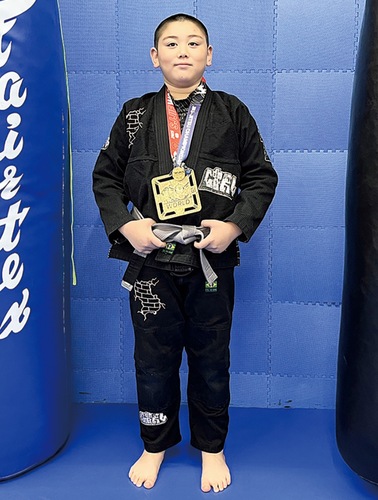 金メダルを胸に笑顔のアレクサンダーさん