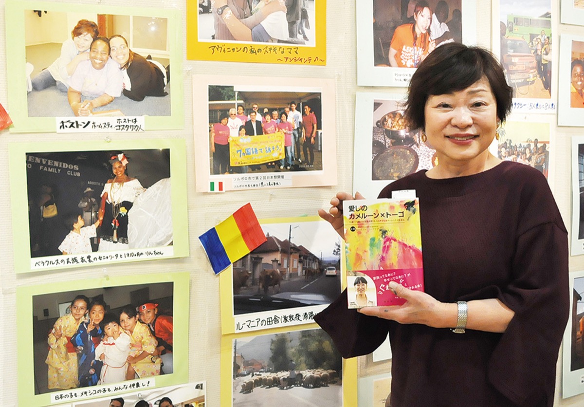 写真の前で著書を手にする中川さん