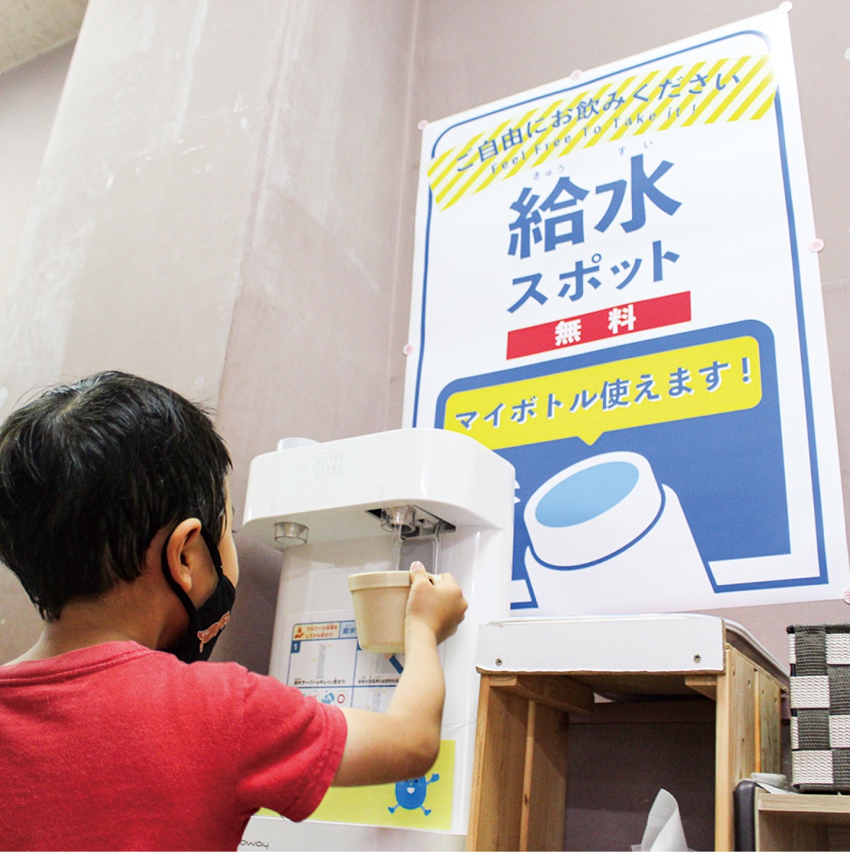 コップに水を注ぐ子ども