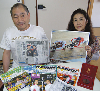 一成さんが載った新聞や雑誌はほとんど取ってあるという渡邉さん。手前のメダルは北京五輪出場時の記念品。