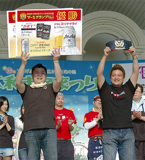 表彰式で満面の笑顔を見せる黒木代表（右）とスタッフの菊地龍希さん