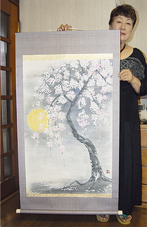 墨彩画「桜舞曲」を持つ渡沼礼子さん