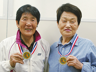 馬の描かれた銀メダルを手に、笑顔の中丸さん（左）と成沢さん