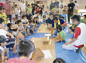 子どもたちが見守るなかで説明する神奈川土建のメンバー