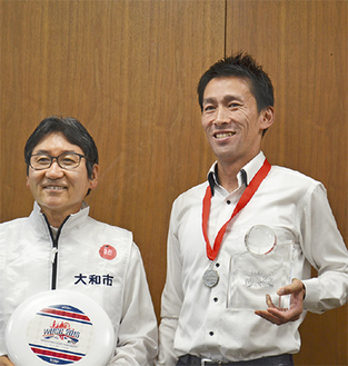 トロフィを手に笑顔の吉川さん（右）と大木市長
