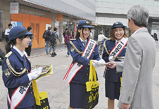 通行者に啓発チラシを渡す（左から）藤田さん、高山さん、河井さん