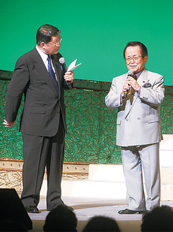 吉川精一さん（左）の司会で歌を披露する小菅会長