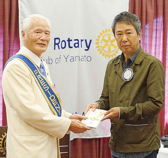 伊藤会長（左）に寄付金を渡す本田社長