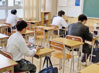 分散登校で空席が目立つ教室で、ポップを机に置き昼食をとる