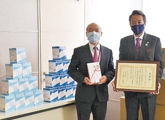 感謝状を持つ本田会長（右）と目録を持つ矢尾病院長（左）