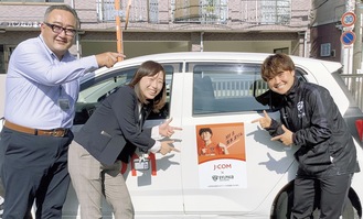 自身の写真が貼られた車両を指さす濱本選手（右）とジェイコムの社員