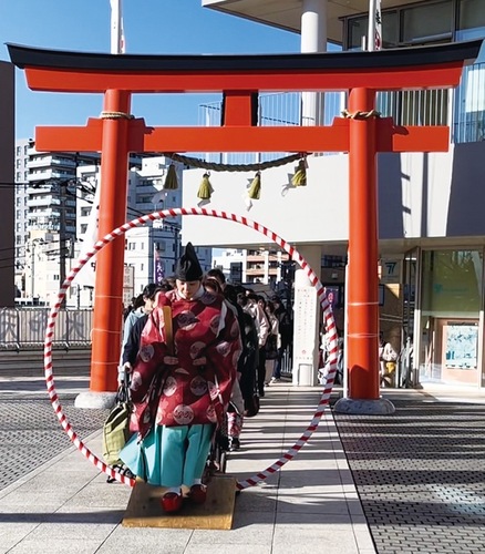 智の輪をくぐる平賀宮司と参列者たち