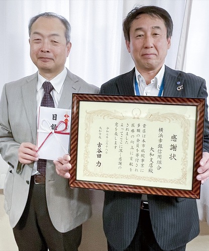 感謝状を手にする成田支店長と目録を受け取った石川病院長