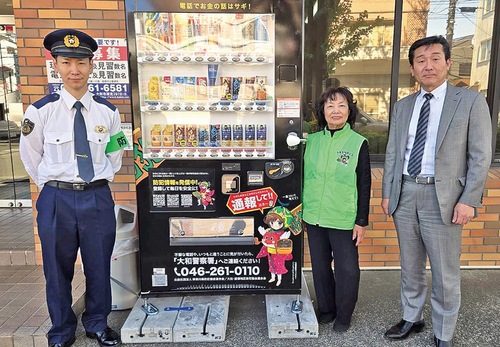 設置された自販機と橋本代表（右）、小菅会長（中央）