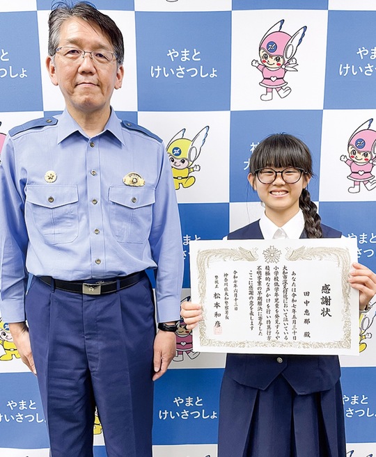 松本署長（左）から感謝状を受け取った恵那さん＝13日・大和警察署