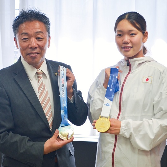 金メダルを手に写真撮影に応じる平井選手（右）と古谷田市長（左）＝10月17日・大和市役所