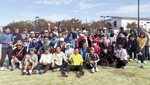 快晴の下で記念撮影する参加者ら