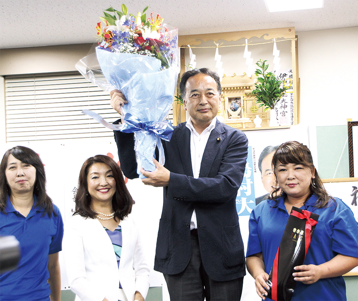 当選確実が報じられ、花束を掲げる島村氏