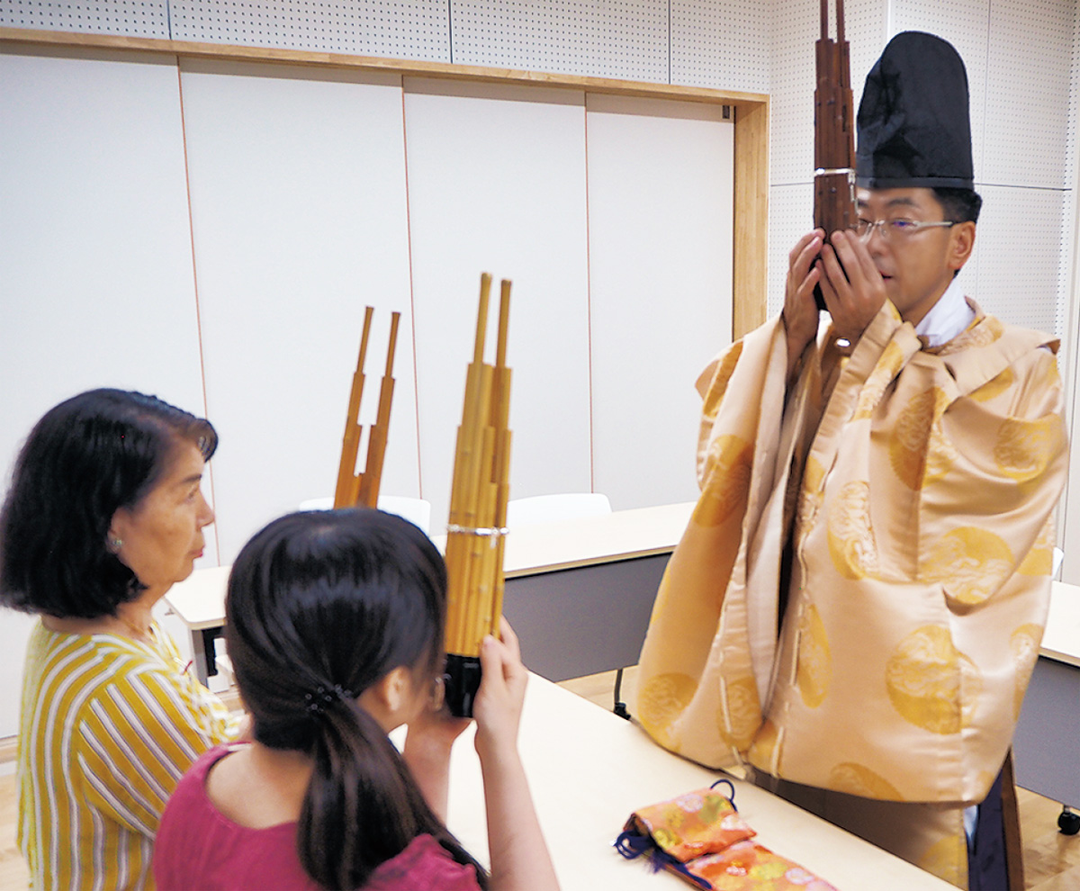 装束に身を包んだ会員が雅楽器を手ほどき