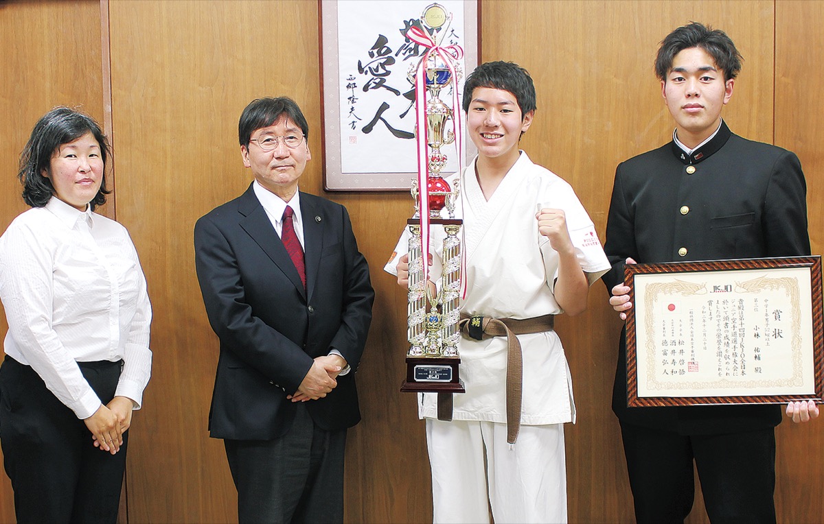 トロフィーを片手に大木市長の隣で微笑む小林佑輔さん左端は佐野代表、右端は佑輔さんの兄の良輔さん