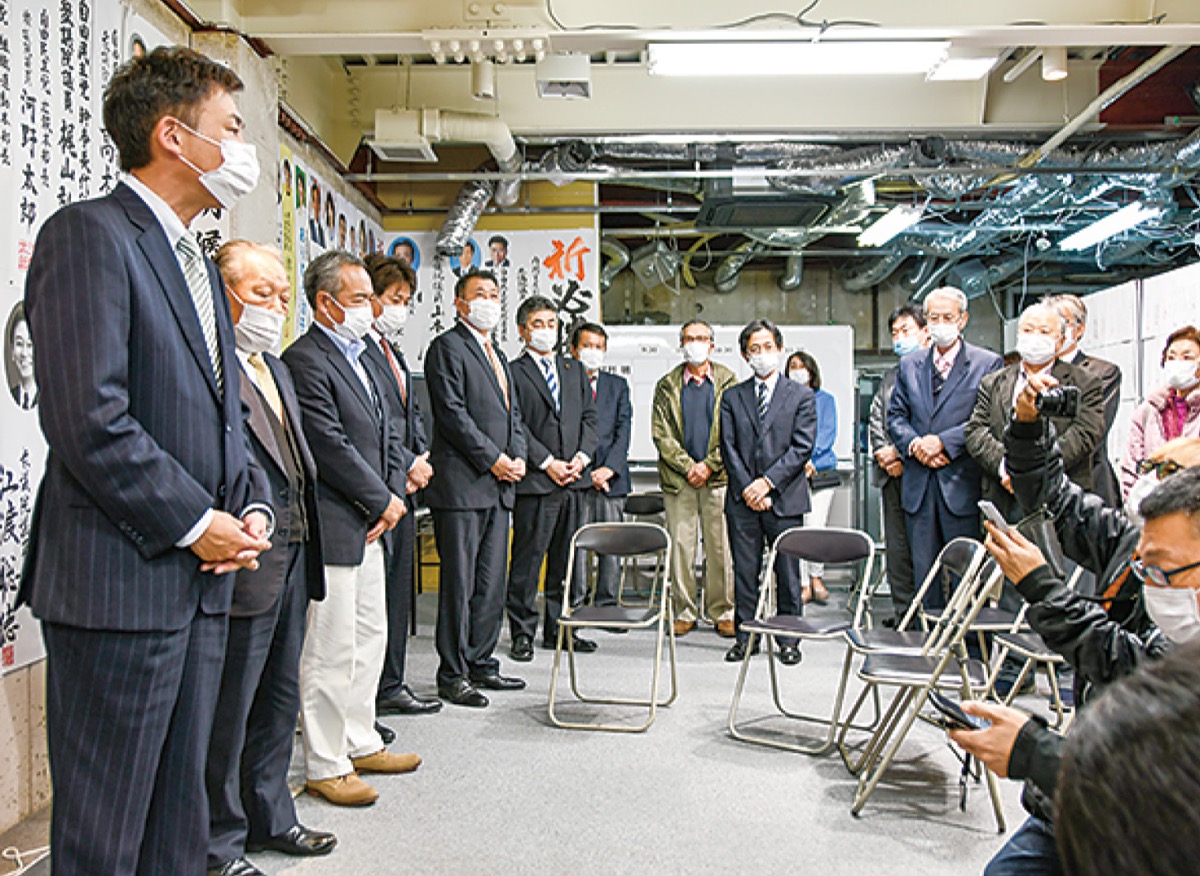 本人不在の事務所で敗戦の弁を述べる陣営幹部ら=10月31日深夜