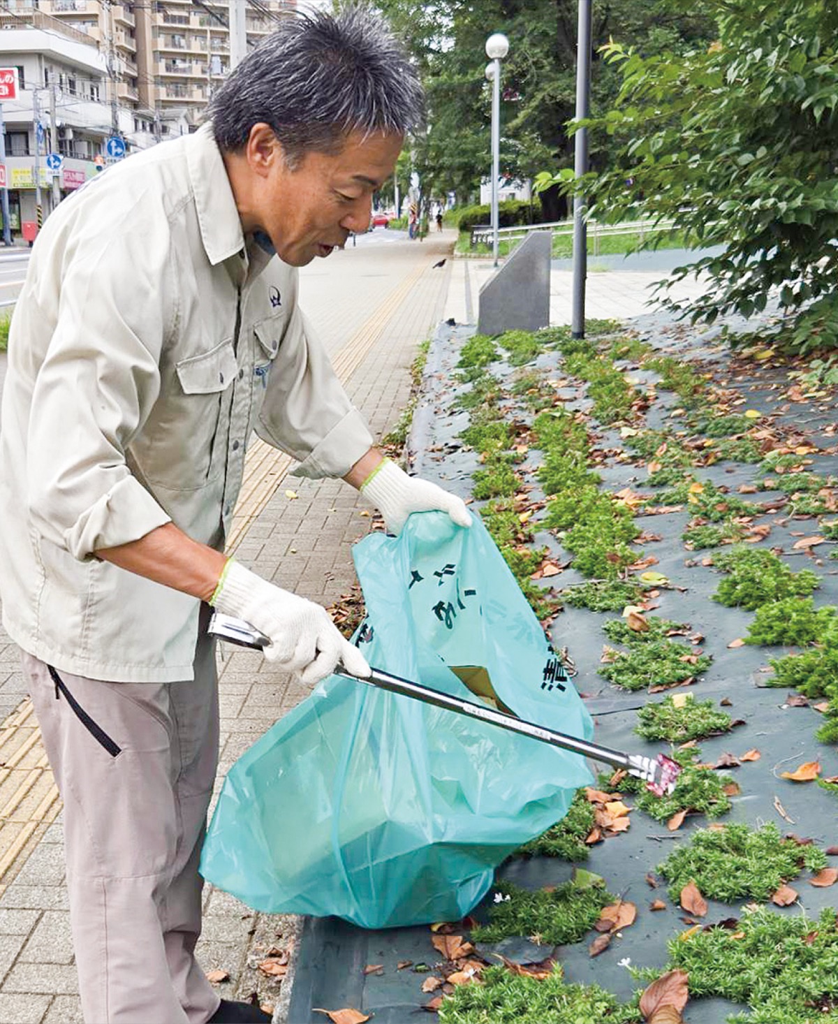 作業着姿で市役所周辺のごみを拾う古谷田市長=8月17日撮影