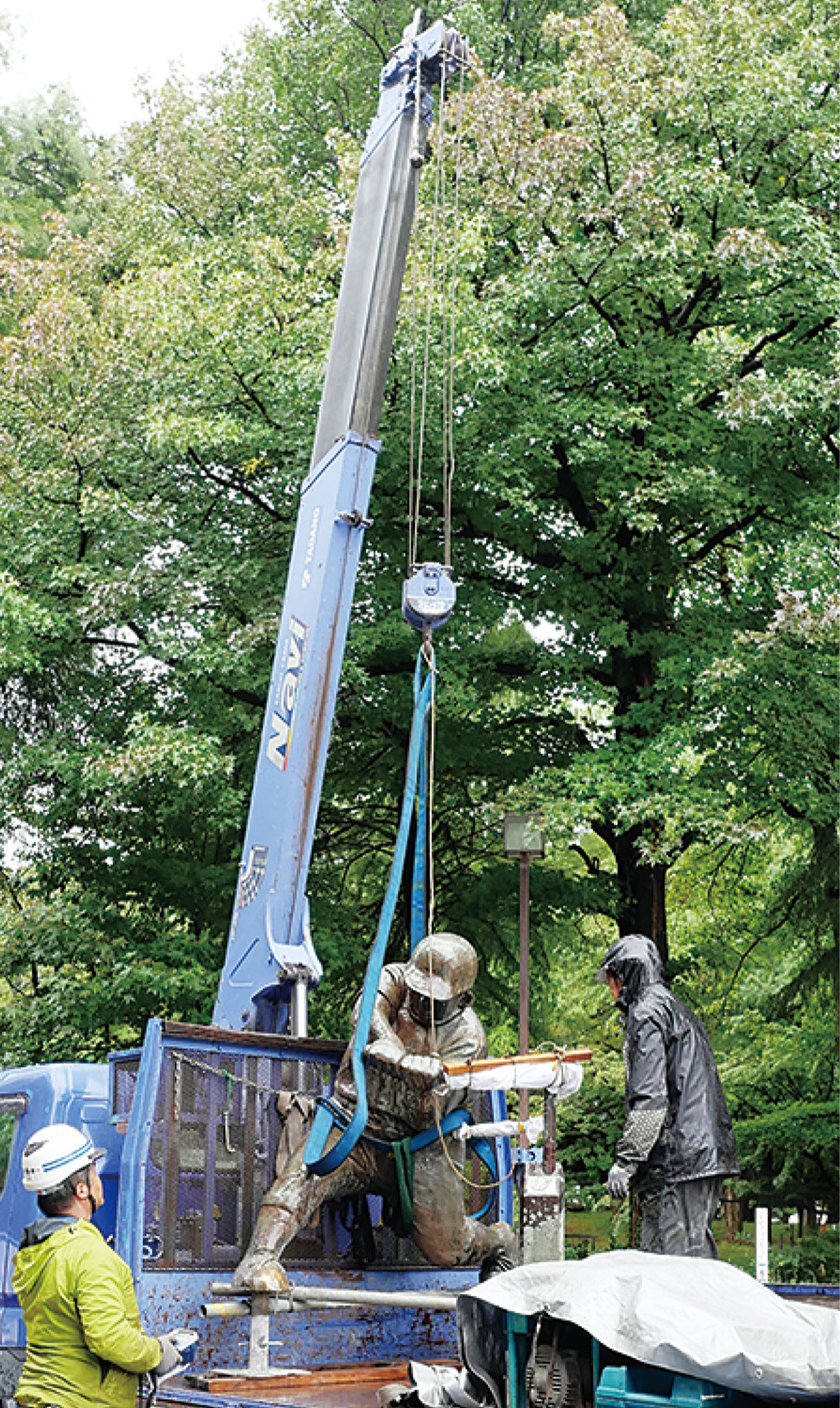 クレーンでつり上げられている山田太郎像（市提供写真）