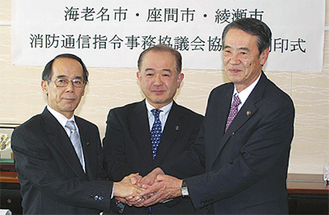 調印式では内野市長（左）ら３市長ががっちり握手