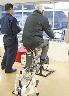 警察署員に指導を受けながら自転車運転シミュレーターを体験し自身の運転技術を再確認する参加者