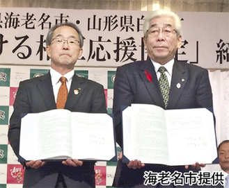 協定書を持つ佐藤町長（右）と伊藤副市長（左）