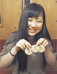 ３つのメダルを手に微笑む雪田さん