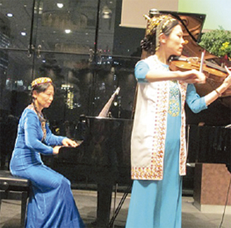 民族衣装で演奏する甘利さん（左）