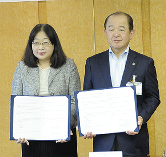 協定締結式での座間市の遠藤市長と金子代表（左）