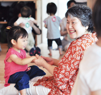 ハリのある田村さんのわらべうたに合わせて、笑顔でリズムを取る子どもたち（６月26日取材）