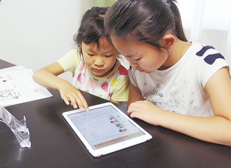 タブレットで家庭学習する小学３年生と１年生の姉妹（写真はイメージ）
