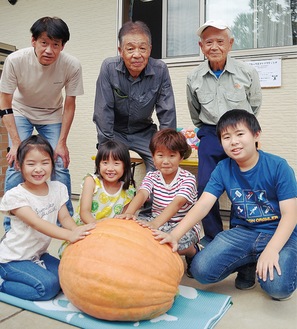 かぼちゃを囲む子どもたち。後列右が萩原さん＝ひなた保育園