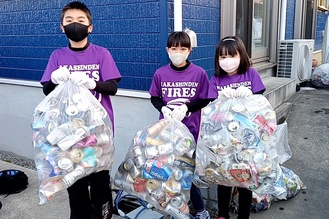 空き缶を持つ子どもたち