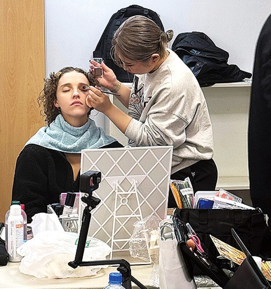 モデルにヘアメイクを施す鶴指さん（24年９月・提供写真）