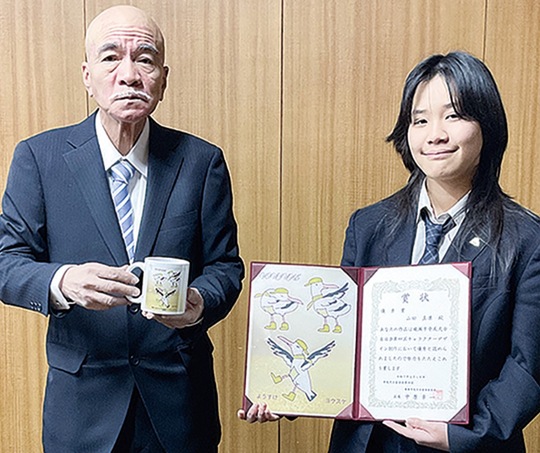 賞状を持つ山田さん（右）と記念品を渡す中原区長