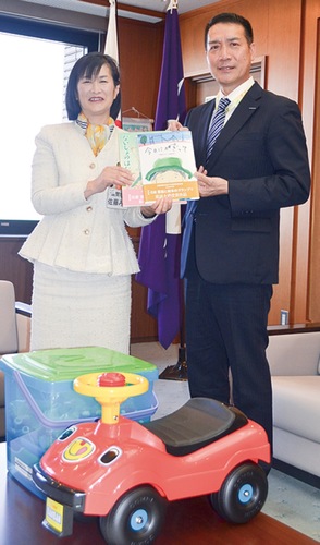 絵本を手渡す黒須課長（右）