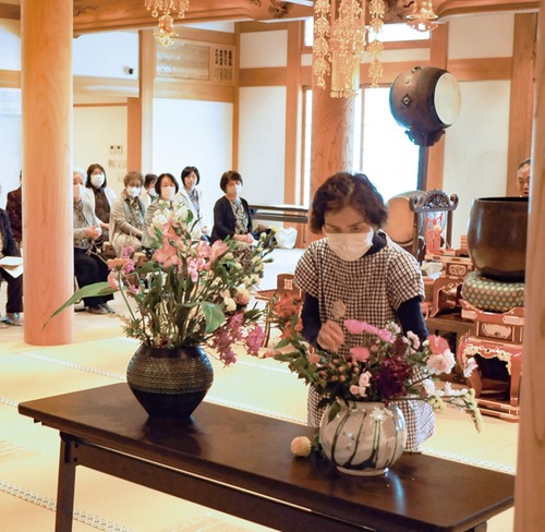 持ち寄った花を生ける参加者