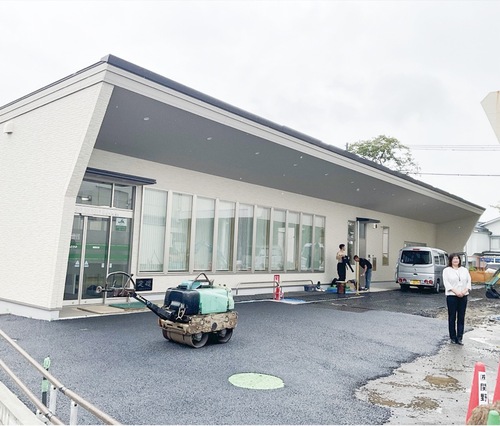 段差の少ないバリアフリーの建物と原支店長（右）