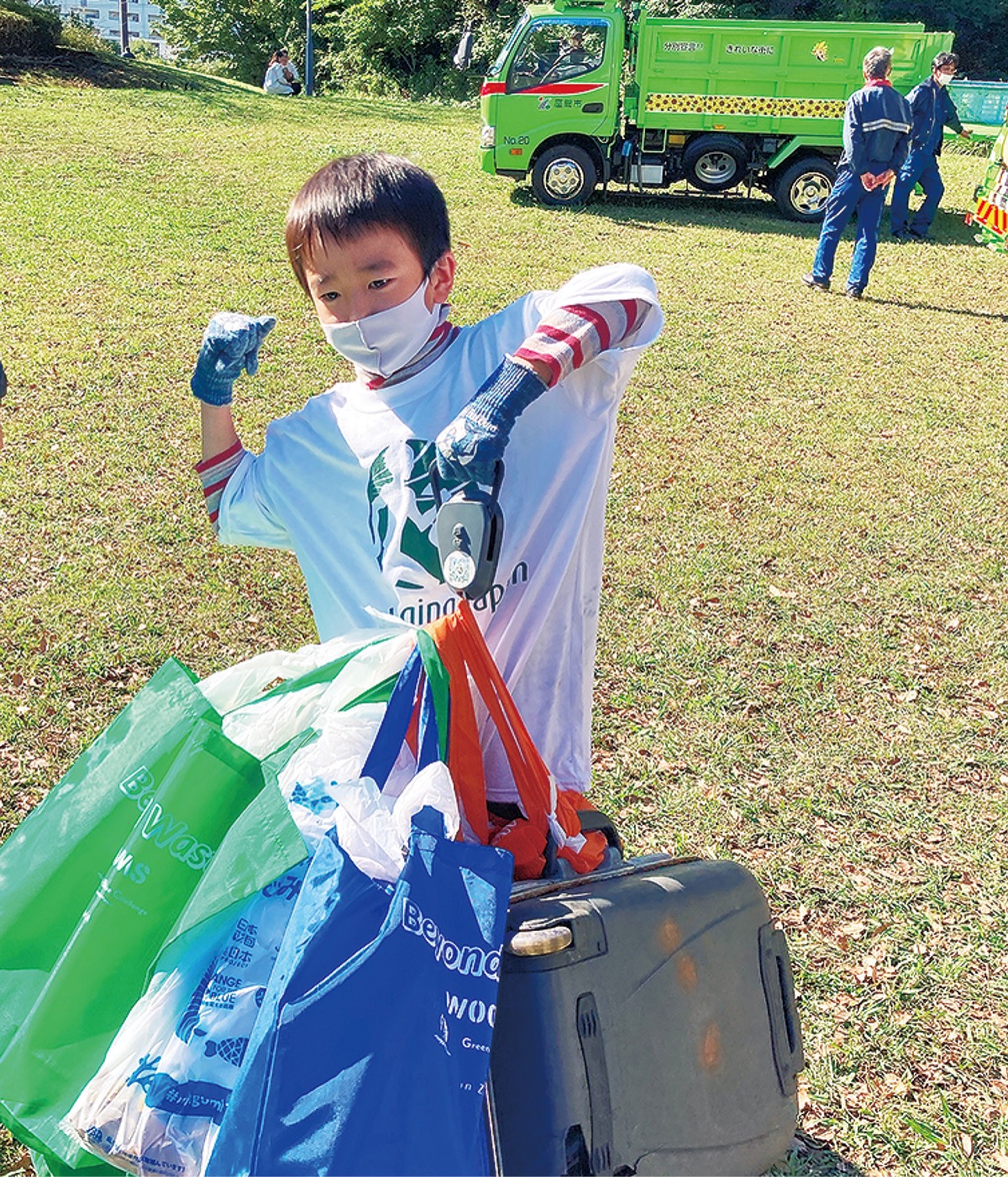 ゴミを計測する子どもとパッカー車
