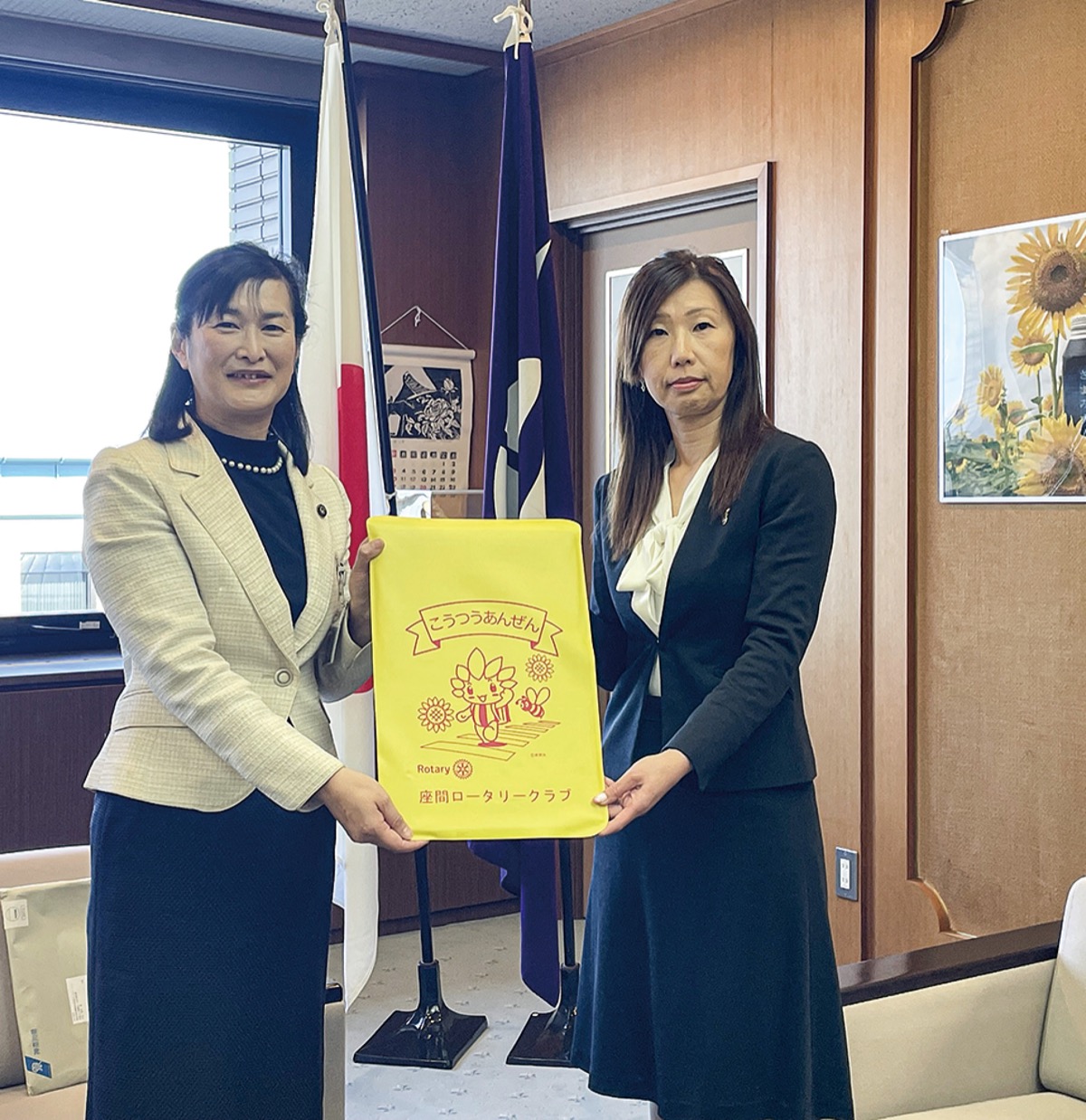 佐藤市長にランドセルカバーを手渡す座間ロータリークラブの佐藤京子会長(右)