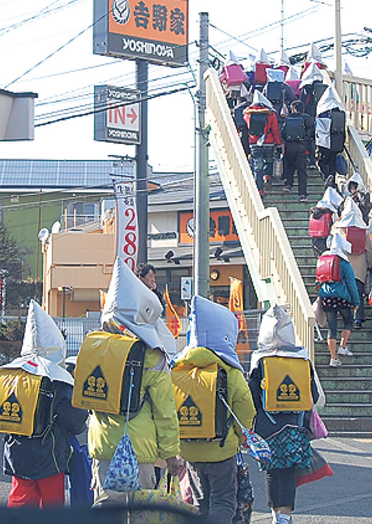 防災頭巾で歩く小学生