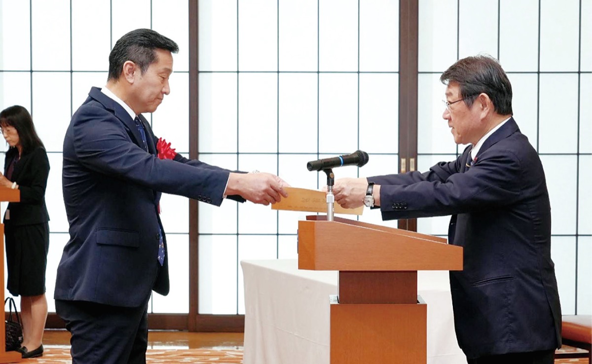 茂木外務大臣から表彰状を受け取る橋本会長(左)