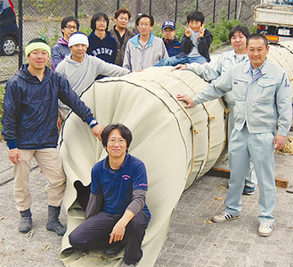 完成した松明を囲む濱野会長（写真中央）とメンバー